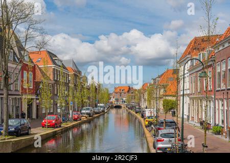 Delft, Paesi Bassi - 26 aprile 2023: Vecchio canale di Delft in primavera con edifici sul mare e cielo blu Foto Stock