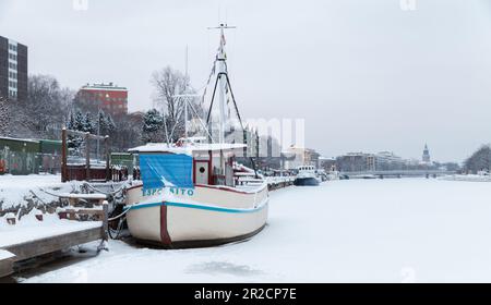 Turku, Finlandia - 17 gennaio 2016: Imbarcazione bianca d'epoca ormeggiata sulla costa del fiume in una giornata invernale Foto Stock