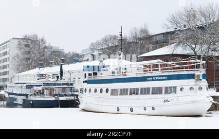 Turku, Finlandia - 17 gennaio 2016: Ristorante galleggiante su una barca bianca d'epoca ormeggiata sulla costa del fiume Foto Stock