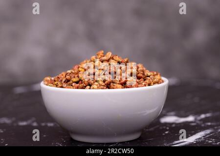 Semi di Sumac. Bacche di suma essiccate su fondo scuro. Concetto di spezia Foto Stock