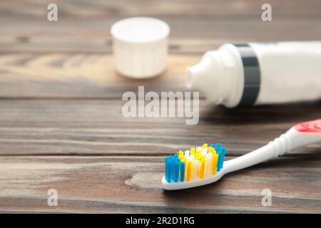 Spazzolini in vetro con tubo di dentifricio su fondo marrone. Vista dall'alto Foto Stock