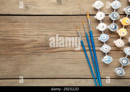 Pitture per disegnare immagini con numeri su sfondo grigio. Vista dall'alto Foto Stock