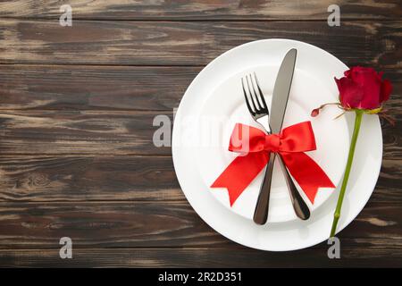 Impostazione tavolo festivo per San Valentino su sfondo marrone. Vista dall'alto Foto Stock