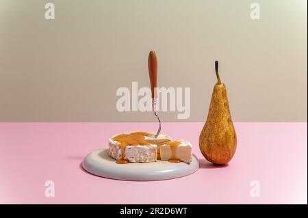 brie formaggio su un piatto con miele e pera Foto Stock