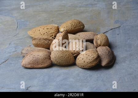 Mandorle fresche, appena raccolte dall'albero. Foto studio con sfondo in pietra. Ambiente rurale. Spazio di copia. Foto Stock