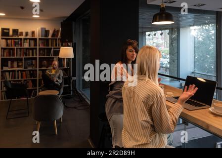 Due ragazze studentesche della serie Z che guardano il webinar, frequentano lezioni online, conferenze di apprendimento, parlano con l'insegnante in videochiamata, ridono, scrivono, stud Foto Stock