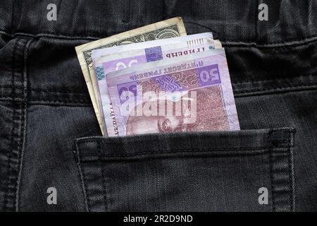 50 UAH giacere in una tasca di jeans di pantaloni neri primo piano, denaro ucraino Foto Stock