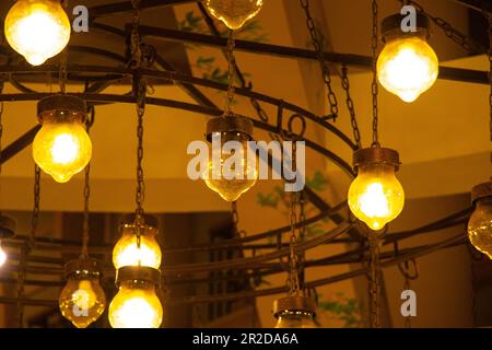 vecchio lampadario sulla parete in una sala buia al coperto Foto Stock