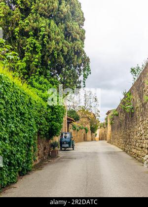 Un vecchio tre ruote sulle strade acciottolate di San Quirico d'Orcia Foto Stock