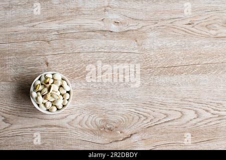 Dadi in una tazza su una vecchia tavola di legno grano angolo sinistro e prendere un primo piano e vista dall'alto, ha copyspace per l'immissione di testo, la foto è un paesaggio Foto Stock