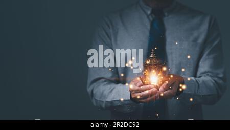 Uomo d'affari o uomo con lampade, lanterne arabe decorate con candele accese di notte su un Ramadan musulmano. Festival EID al Fdr, Eid al Adha Foto Stock