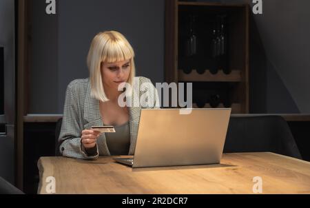 Informazioni rubate nel processo di pagamento. Carta di credito di plastica hold femminile confusa non in grado di accedere al sito web del conto di fatturazione. Donna cleen delusa Foto Stock