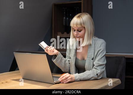 Informazioni rubate nel processo di pagamento. Carta di credito di plastica hold femminile confusa non in grado di accedere al sito web del conto di fatturazione. Donna cleen delusa Foto Stock