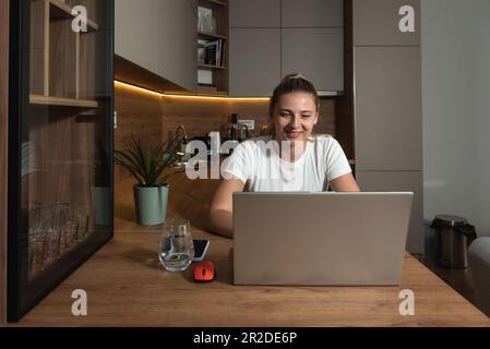 Intervista di ricerca di lavoro di giovane donna d'affari freelance sulla video chiamata da casa con l'azienda di cui ha risposto all'annuncio. La giovane ragazza che lavora usa il laptop Foto Stock