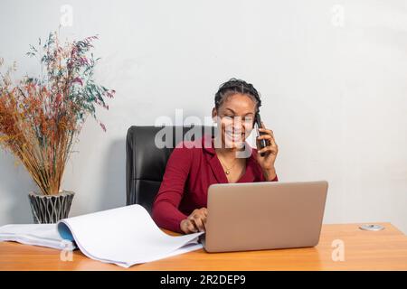donna africana che effettua una telefonata mentre lavora nel suo ufficio Foto Stock