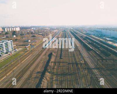 Fotografia aerea dall'alto verso il basso del mozzo del trasporto ferroviario che mostra i diversi treni parcheggiati l'uno accanto all'altro sulle rotaie Foto Stock