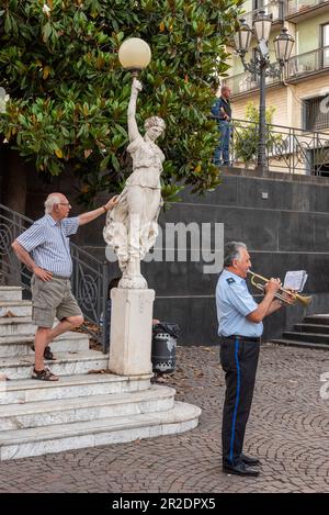 Un membro della banda cittadina suona la tromba nella piazza centrale della città siciliana di Zafferana Etnea, sulle pendici dell'Etna Foto Stock