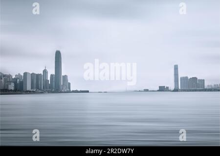 Vista dello skyline di Hong Kong e di Kowloon Ovest e alti edifici dalla passeggiata fronte porto Foto Stock