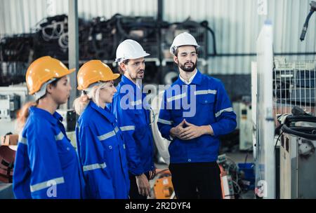 Un gruppo di ingegneri robotici collabora con un brainstorms e discute idee con team interfunzionali su una lavagna per creare strategie e solu Foto Stock