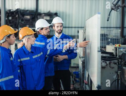 Un gruppo di ingegneri robotici collabora con un brainstorms e discute idee con team interfunzionali su una lavagna per creare strategie e solu Foto Stock