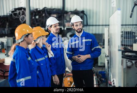 Un gruppo di ingegneri robotici collabora con un brainstorms e discute idee con team interfunzionali su una lavagna per creare strategie e solu Foto Stock