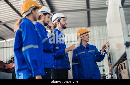 Un gruppo di ingegneri robotici collabora con un brainstorms e discute idee con team interfunzionali su una lavagna per creare strategie e solu Foto Stock