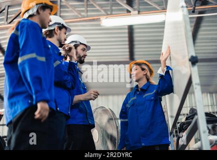 Un gruppo di ingegneri robotici collabora con un brainstorms e discute idee con team interfunzionali su una lavagna per creare strategie e solu Foto Stock