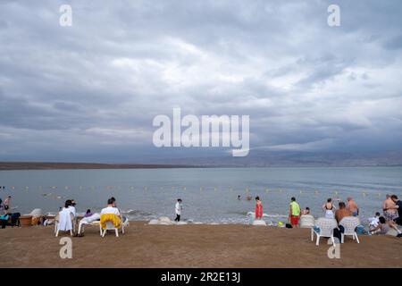 Mar Morto, Distretto Meridionale, Israele - 11 Aprile, 2023.Tourists godendo di una spiaggia in mare morto. Foto Stock