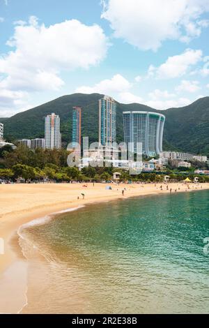 Hong Kong SAR, Cina - Aprile 2023: Alti edifici grattacieli e spiaggia con sabbie dorate a Repulse Bay Foto Stock
