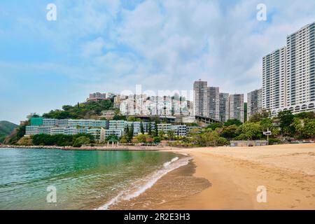 Hong Kong SAR, Cina - Aprile 2023: Alti edifici grattacieli e spiaggia con sabbie dorate a Repulse Bay Foto Stock
