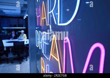 Lavorare duro sogno grande neon segno in ufficio Foto Stock