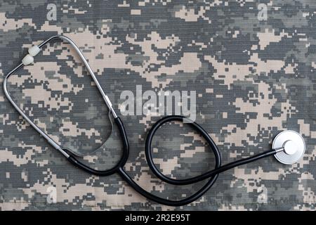 Lo stetoscopio si trova sull'uniforme di un soldato statunitense. Il concetto di assistenza sanitaria, assicurazione militare, assistenza statale. Vista dall'alto. Supporti misti Foto Stock