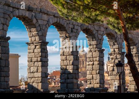 La Cattedrale di Segovia, vista attraverso le colonne dell'acquedotto. Splendidi colori del tramonto sulla cattedrale. Destinazione di viaggio Foto Stock