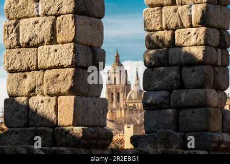 La Cattedrale di Segovia, vista attraverso le colonne dell'acquedotto. Splendidi colori del tramonto sulla cattedrale. Destinazione di viaggio Foto Stock