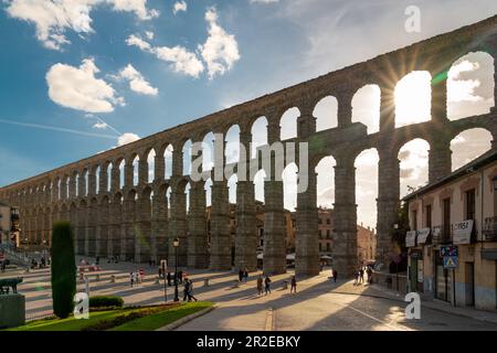 Veduta dell'acquedotto di Segovia. Sensazionale tramonto arancione, visto attraverso gli archi dell'acquedotto. Destinazione turistica di Castilla e Leo Foto Stock