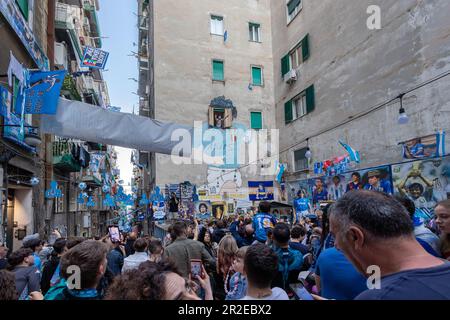 Napoli, Italia - 5 maggio 2023: I tifosi della squadra di calcio Napoli festeggiano la vittoria del campionato italiano in strada. Le persone euforiche si affollano nei quartieri spagnoli di fronte al murale di Maradona. Foto Stock