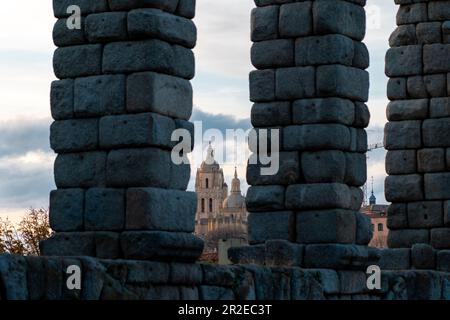 La Cattedrale di Segovia, vista attraverso le colonne dell'acquedotto. Splendidi colori del tramonto sulla cattedrale. Destinazione di viaggio Foto Stock