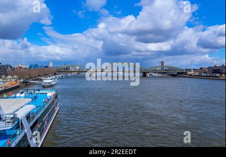 Colonia, Germania - 23 marzo 2023: Il ponte Hohenzollern o Hohenzollernbrucke attraverso il fiume Reno con navi, ponte pedonale e ferroviario in acciaio, Co Foto Stock