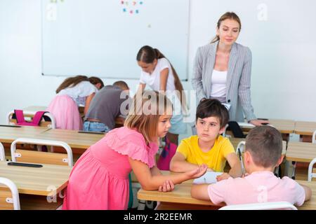 Figli che eseguono attività di gruppo Foto Stock