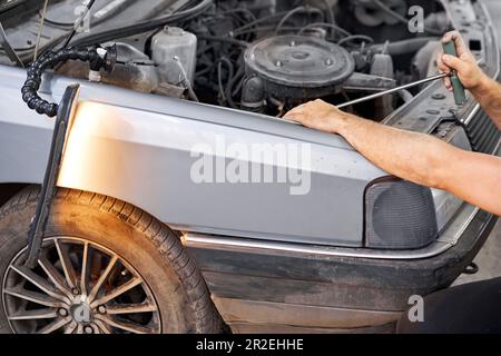 Rimozione delle ammaccature sulla vettura. Tecnologia PDR. Riparazione della carrozzeria senza verniciatura. Foto Stock