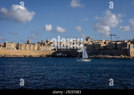 Valletta, Malta - 18 aprile 2023: Una vista da Sliema alla vecchia Valletta. Piccola barca a vela in primo piano. Foto Stock