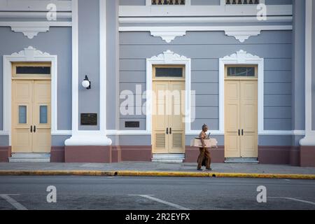 Uomo di fronte alla facciata di casa del Palacio de Gobierno a Cienfuegos, Cuba Foto Stock