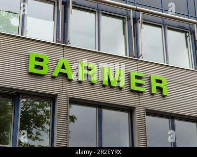 Logo di assicurazione sanitaria Barmer sulla facciata di un edificio. Fornitore tedesco sul mercato sanitario. Le lettere verdi dell'azienda si trovano all'esterno. Foto Stock