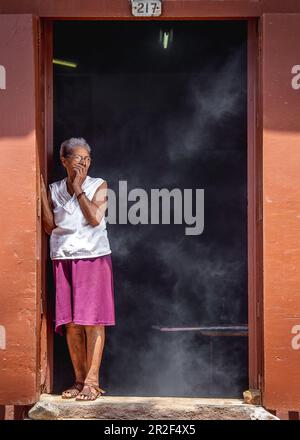 Donna tosse perché fuma in cucina, Trinidad, Cuba Foto Stock