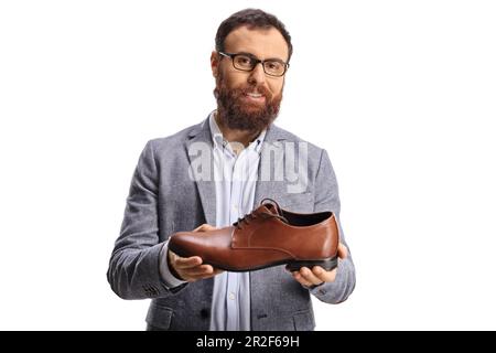 Giovane uomo beared che tiene un'elegante scarpa in pelle marrone isolata su sfondo bianco Foto Stock