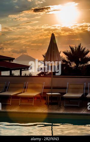 Vista sul vulcano Stromboli con piscina e mare in primo piano Foto Stock