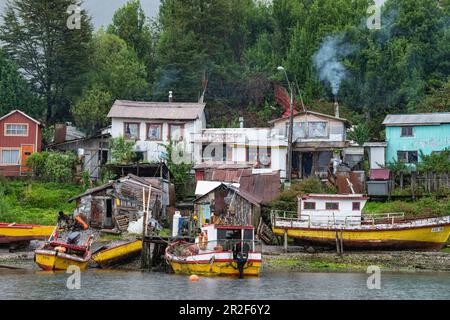 Barche e capanne fiancheggiano questo segmento dei fiordi altrimenti scarsamente popolati, Villa Puerto Edén, Wellington Island, Natales, Magallanes y de la Antarti Foto Stock