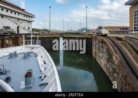 Una nave da crociera di spedizione nel canale di Panama si prepara a lasciare il blocco Miraflores con la tribuna sulla destra, vicino a Panama City, Panama, CE Foto Stock