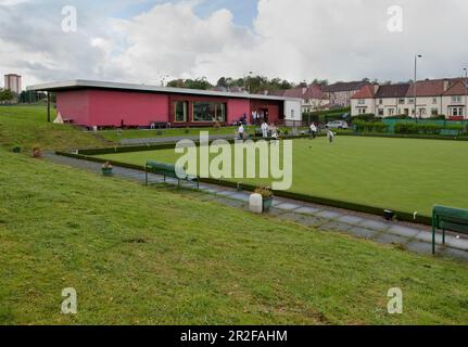 Bocce in gioco di fronte al circolo del padiglione rosso presso il campo da bowling Balornock a Glasgow, Scozia, Regno Unito Foto Stock