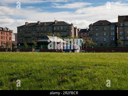 I ragazzi giocano a bocce di fronte al padiglione del campo da bowling Kelvingrove a Glasgow, Scozia, Regno Unito Foto Stock